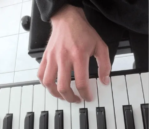 Main droite bien arrondie sur les touches du piano