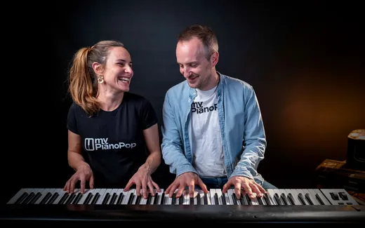Deux personnes qui rient en jouant ensemble au clavier