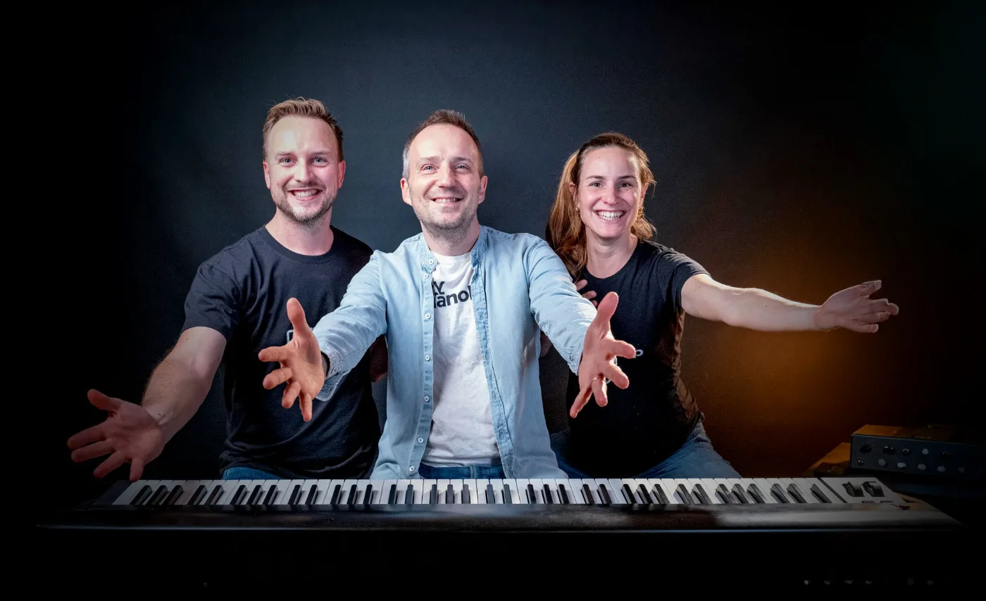 L’équipe MyPianoPop : Edouard, Cyrille et Anaïs, bras ouverts derrière le clavier